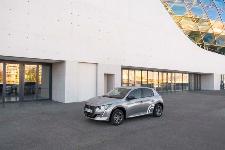 Peugeot e-208 électrique stationnée devant un bâtiment moderne – véhicule en location avec Free2Move à Valence, Drôme